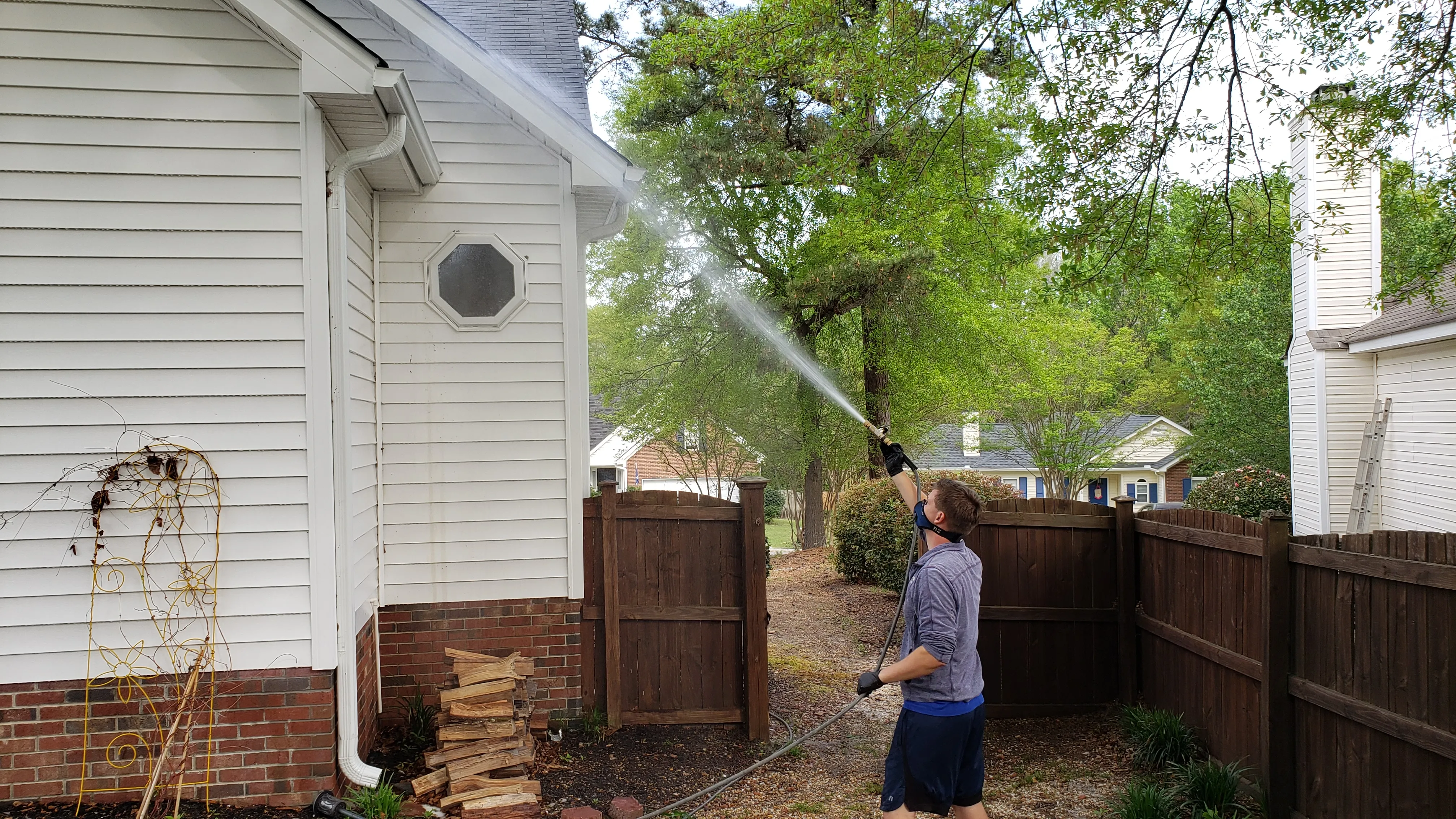 Team member cleaning a house's exterior.